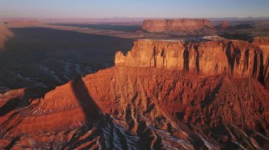 Epic sunrise light shinning on red canyon cliff wall, rocks on background