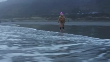 Dramatic epic aerial shot drone flying around woman traveler with backpack 4K