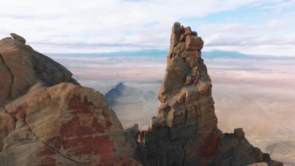 Drone flying around tall rocky peak formation with desert on motion background — Stock Video