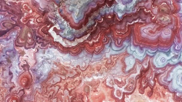 Top down aerial view red, pink and blue painted desert surface like water waves — Stock Video