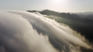 Epic cloudscape view sunset, Beautiful white clouds flowing above mountain peaks