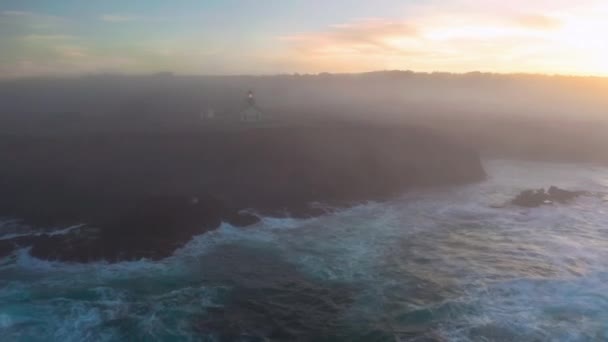 Lighthouse light on rocky shore at sunrise, lighthouse illuminated at morning 4K — Stok video