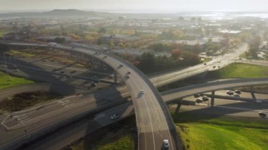 4K insansız hava aracı güneşli bir gecede çok katlı karayolu kavşağında uçuyor.