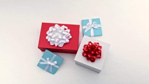 Hermoso conjunto de cajas de regalo rojas, azules y blancas con cintas blancas elegantes y arcos — Vídeo de stock
