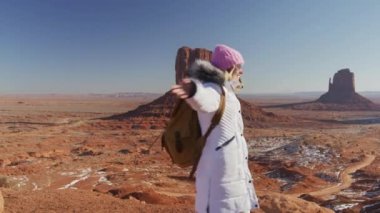 Parlak güneşe bakan mutlu gezgin, hareketli arka planda vahşi batı manzarası