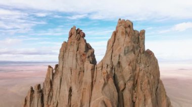 Keskin bir tepe ile muazzam kayalık Shiprock formasyonu üzerinde hava görüntüsü
