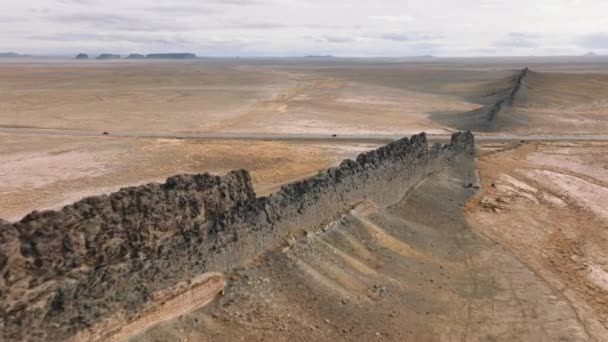 空中拍摄的是广阔的 长长的岩石山脉 绵延着广阔的沙漠 车辆在新墨西哥州船岩周围的国家保护区内行驶 风景贫瘠 高质量的4K镜头 — 图库视频影像