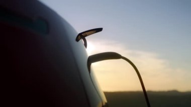 4K dolly çekim sıfır emisyon elektrikli araba istasyonda şarj güzel altın bulutlar gün batımında arka planda dağlar üzerinde. Sinematik çevre ve çevre dostu teknoloji otomobili, ABD Doğa