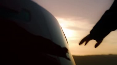 Otomobilin şarj prizinde şarj kablosu takan insanlar