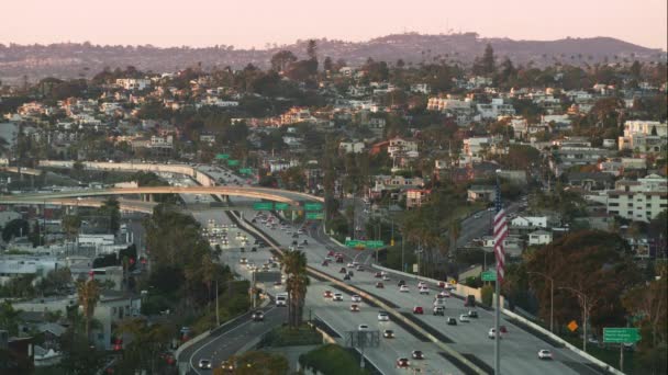 View from high skyscraper on cars driving by highway at pink sunset, San Diego — Stock Video