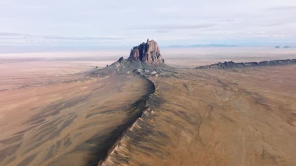 Gigante formazione rocciosa al centro del terreno pianeggiante con campo di pietra — Video Stock