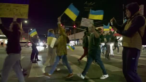 Sarı ve mavi Ukrayna bayrakları ve DUR SAVAŞ, DUR PUTIN işaretleri sallayan kalabalık — Stok video