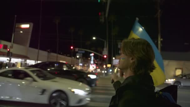Man met blauwe gele vlag tijdens flitsmeute ter ondersteuning van Oekraïne, RED Camera — Stockvideo