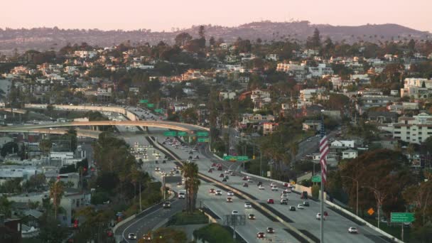 Uitzicht vanaf hoge wolkenkrabber op auto 's rijden door de snelweg bij roze zonsondergang, San Diego — Stockvideo