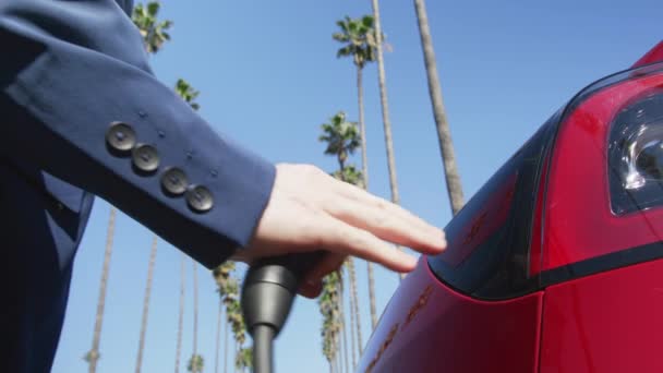 Мужская рука подключить кабель к экологически чистой нулевой выбросов электрический автомобиль 4K — стоковое видео