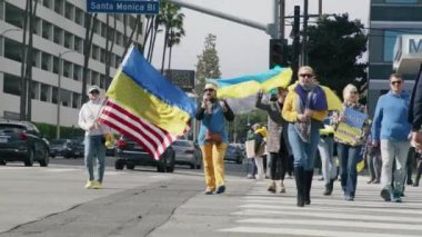 Ukrayna 'da savaşı protesto eden sarı mavi Ukrayna bayrakları sallayan insanlar