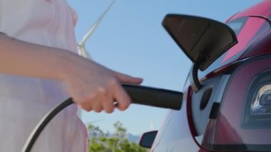 Elektrikli arabaları açan kadın baltayı takıyor ve fişe takıyor, RED kamera.