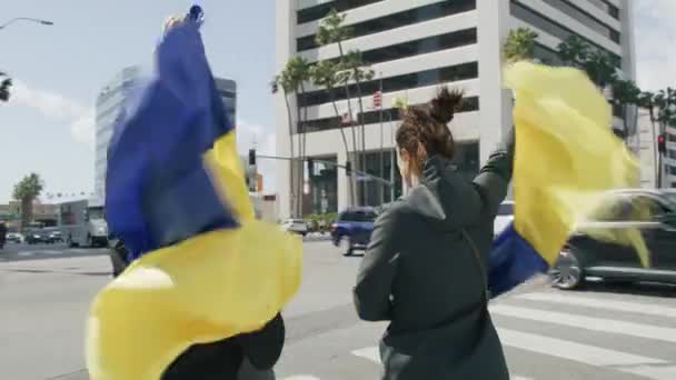 Люди з жовтими синіми українськими прапорами протестують проти війни в Україні. — стокове відео