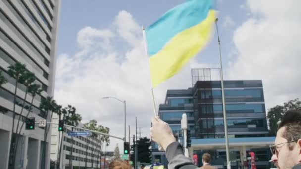 Люди с желтыми голубыми украинскими флагами протестуют против войны на Украине — стоковое видео