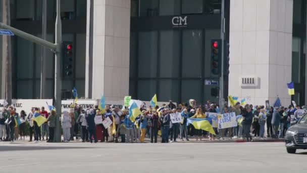 Des gens avec des drapeaux jaunes bleus ukrainiens protestant contre la guerre en Ukraine — Video