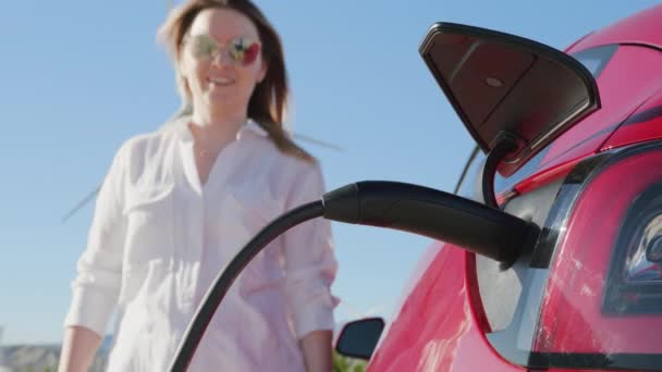 Zbliżenie spowolnienie ruchu Kamera RED nakręcona pod włazem, gdzie ładuje się elektryczny samochód ekologiczny — Wideo stockowe