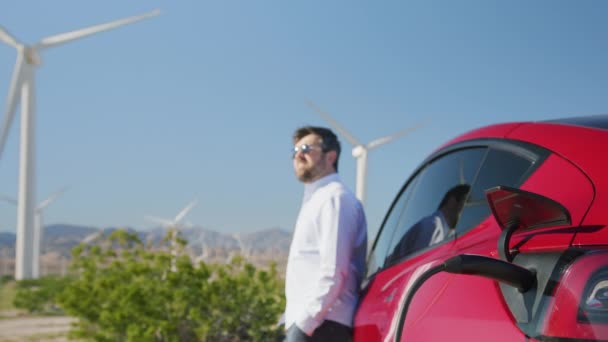 Entreprenör man med väderkvarnar på klarblå himmel bakgrund, drömmer framtid — Stockvideo