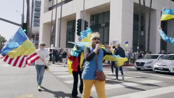 Menschen mit Fahnen der USA und der Ukraine während einer pazifistischen STOP KAR-Kundgebung — Stockvideo