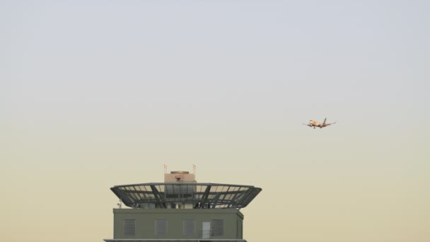 青と黄色の日の出のスカイラインの中を飛行する旅客機の映像 — ストック動画