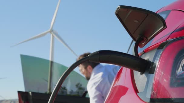 Futurystyczny samochód elektryczny wykorzystujący czystą energię wytwarzaną przez turbiny wiatrowe — Wideo stockowe
