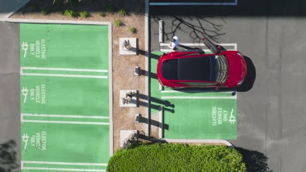 Εναέρια επιχειρηματίας στο κόκκινο σύγχρονο SUV όχημα του για ηλεκτρικό σταθμό φόρτισης 4K — Αρχείο Βίντεο