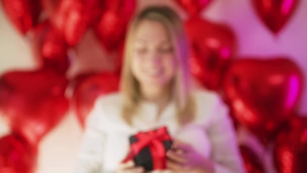 Mulher irreconhecível mostra na câmera caixa de presente de veludo preto fita de cetim vermelho — Vídeo de Stock