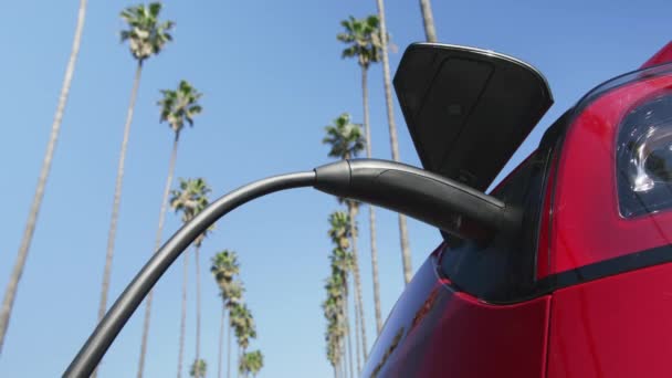 Zbliżenie mężczyzna w klasycznym garniturze mocowanie kabla zasilającego do ekologicznego samochodu elektrycznego — Wideo stockowe