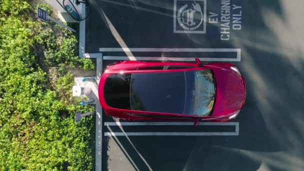 4K bovenaanzicht op wit elektrisch voertuig parkeren bij laadstation — Stockvideo