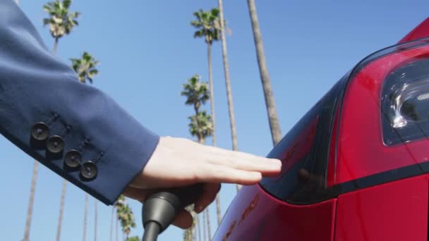 RED камера людини ручний підключення заряджання шнура на електричний транспортний засіб, США — стокове відео