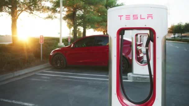 Batería de carga de coche eléctrico en el supercargador en el atardecer dorado cinematográfico, Estados Unidos — Vídeo de stock