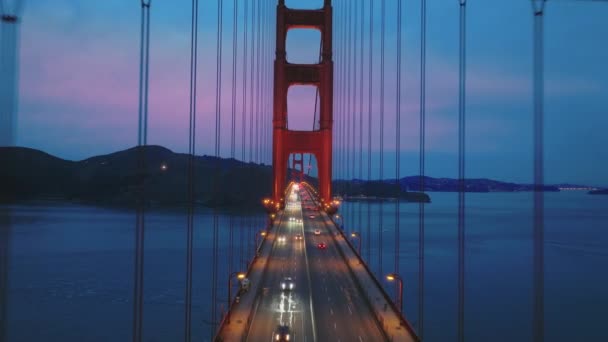 Puente aéreo Golden Gate por la noche, vuelo inspirador de drones a través de la torre roja — Vídeos de Stock