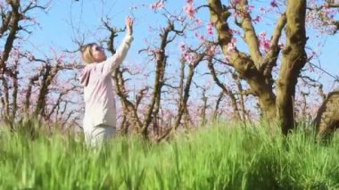 Güzel bir kadın güneşli bir sabahta badem bahçelerini keşfeder.