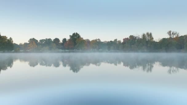 Névoa matinal cinematográfica baixa acima ainda espelho como a superfície da água do lago, Nova York — Vídeo de Stock