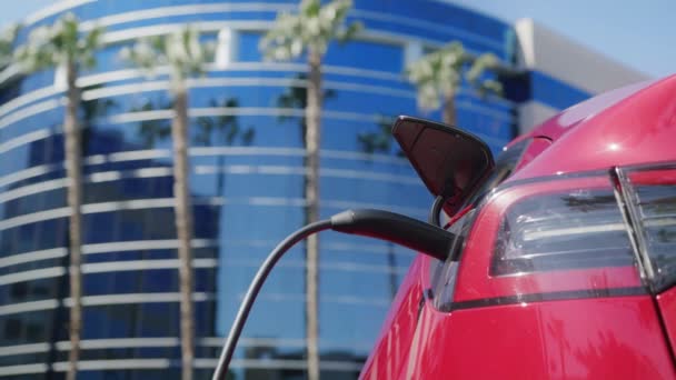 Mujer de negocios en la calle de la ciudad utilizando SUV eléctrico rojo moderno, Dolly tiro en rojo 6K — Vídeos de Stock