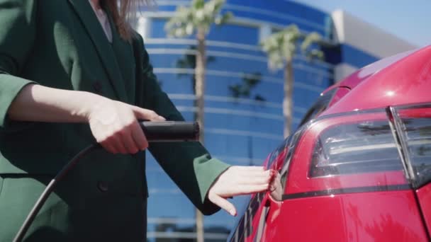 Femme d'affaires sur la rue de la ville recharge moderne SUV électrique rouge, poupée tourné sur ROUGE — Video