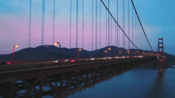 Hava manzaralı kırmızı Golden Gate Köprüsü trafiği ve pembe günbatımı ABD 4K — Stok video