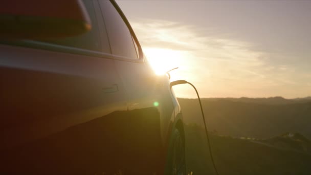 Scenic nul emissie elektrische voertuig SUV opladen bij gouden wolken lucht achtergrond — Stockvideo