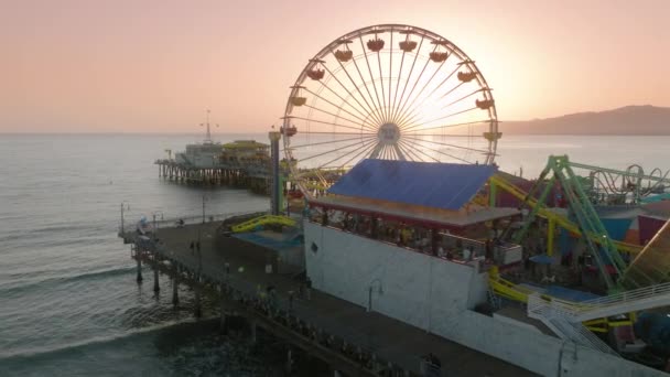 4K tiro aéreo de volta iluminado roda gigante no cais de Santa Monica marco Califórnia — Vídeo de Stock