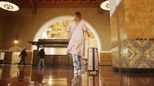 Reisende Frau in legerer Kleidung zu Fuß in Bahnhof oder Busbahnhof 6K — Stockvideo