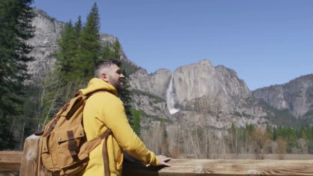Νεαρός γενειοφόρος άνδρας με τουριστικό σακίδιο χαλαρώνει στην κοιλάδα Yosemite, ΗΠΑ 6K — Αρχείο Βίντεο