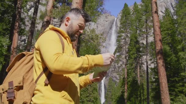 Toeristen met rugzak levensstijl wandelen in het groene bos bij Yosemite waterval 6K — Stockvideo