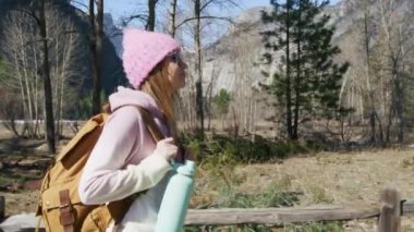 Spor kıyafetli yorgun bir kadının portresi. Sırt çantası ve spor şişesiyle 6K yürüyüşü.