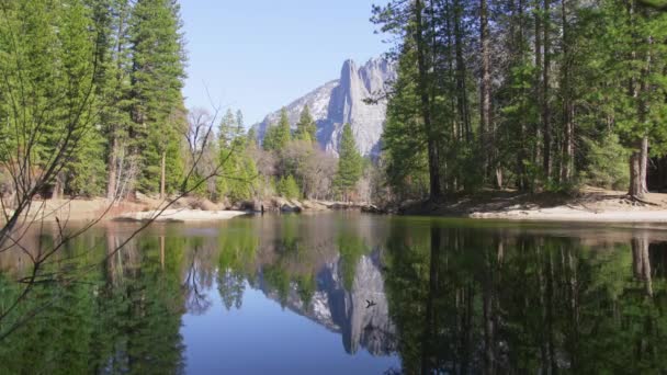 Scenic peaks reflected in clear water surrounded by green pine forest, RED shot — Stock Video