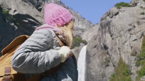 Opgewonden jonge wandelaar vrouw met toeristische rugzak op zoek naar Yosemite waterval — Stockvideo