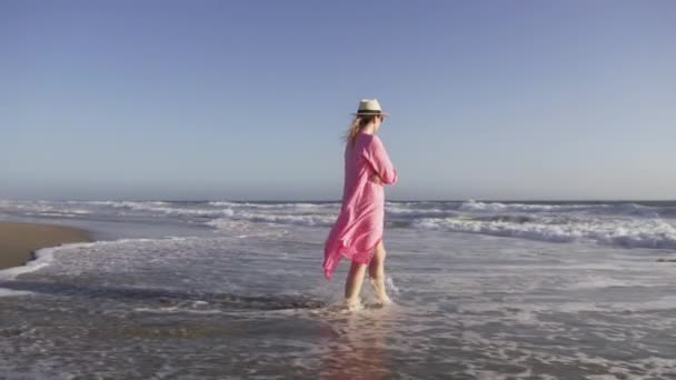 Menina bonita com chapéu de palha desfrutando de banho de sol na praia, jovem mulher elegante vermelho — Vídeo de Stock